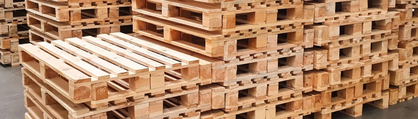 Rows of wooden pallets stacked in large industrial warehouse ready for distribution UAE